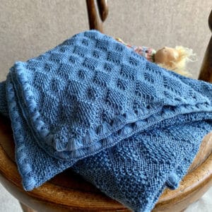 Disana Babydecke aus Merinoschurwolle mit einem Ajourstrickmuster in blau