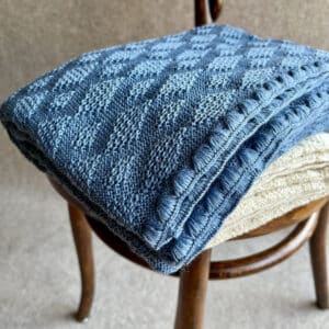 Disana Babydecke aus Merinoschurwolle mit einem Ajourstrickmuster in blau