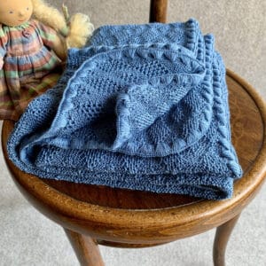 Disana Babydecke aus Merinoschurwolle mit einem Ajourstrickmuster in blau
